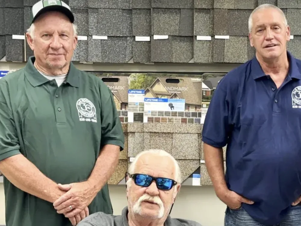 James Sisk, owner of S&S Roofing (seated, center), with the S&S Roofing team at the Taylorsville, NC showroom